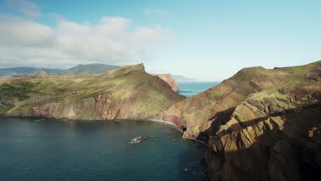 aerial view of tropical island coastline, rocky cliffs, sunny day