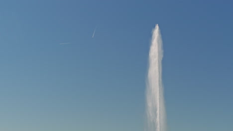 peaceful morning in geneva with the iconic jet d’eau rising from the lake, calm waters reflecting the clear sky, and the city slowly coming to life in the morning light.