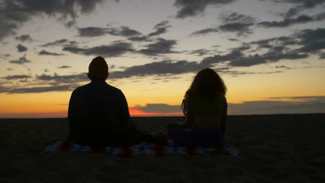 meditating couple at sunset