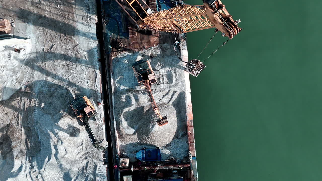 Aerial view of construction site near green water, industrial activity