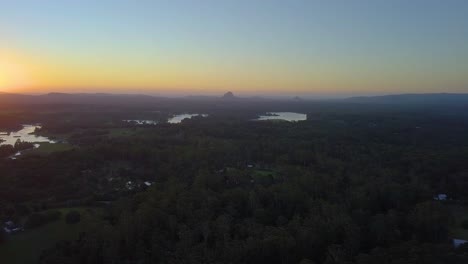 Aerial-view-of-Australia's-landscape-with-forests,-lakes,-mountain-and-beautiful-orange-sunset