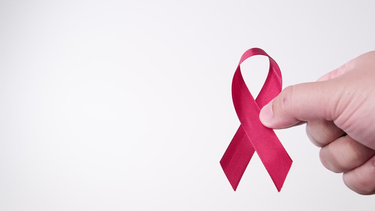 detalle de la mano masculina poniendo cinta en color rojo sobre fondo blanco