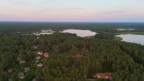 aerial sunset view over dzirnezers lake in carnikava, latvia gauja village, siguļi, krievu island and distant baltic sea horizon in scenic natural landscape captured by drone