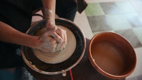 dos tipos usan la rueda del alfarero para crear un producto de arcilla hecho a mano