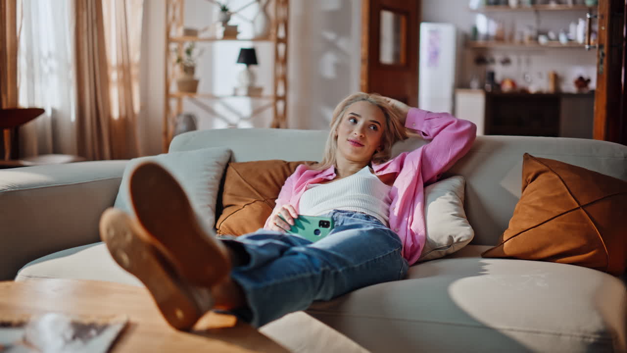 Chilling woman lying couch playing with hair at modern living room. Girl resting