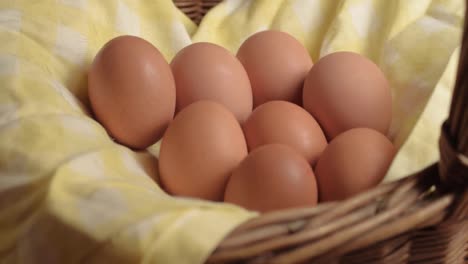 fresh brown eggs in a woven basket tilt shot