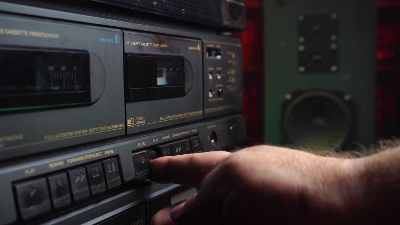 Registrazione su cassetta audio, inserimento e pressione del tasto Play su un lettore a doppio deck.