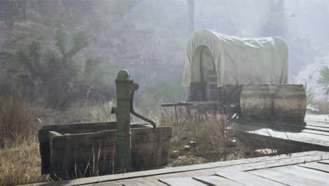 a covered wagon and water pump in the desert