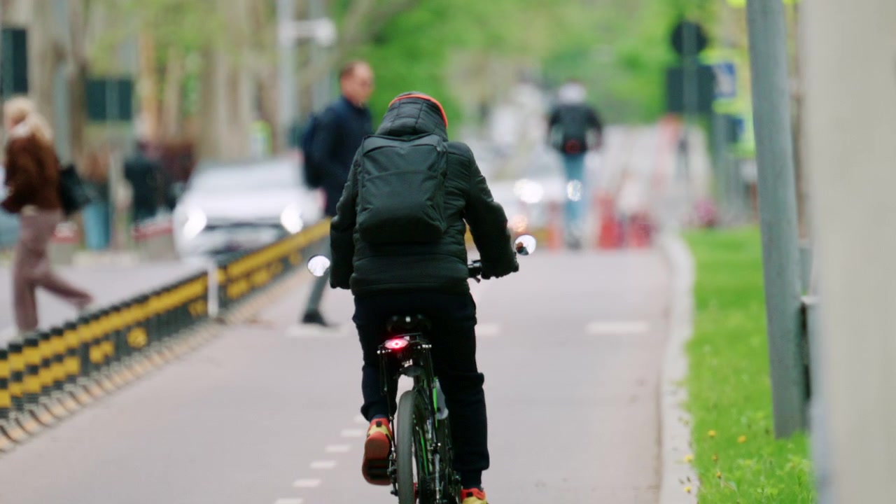 Rear view of a cyclist riding through an urban street in the city center