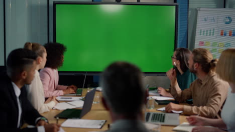 coworkers working in meeting room together