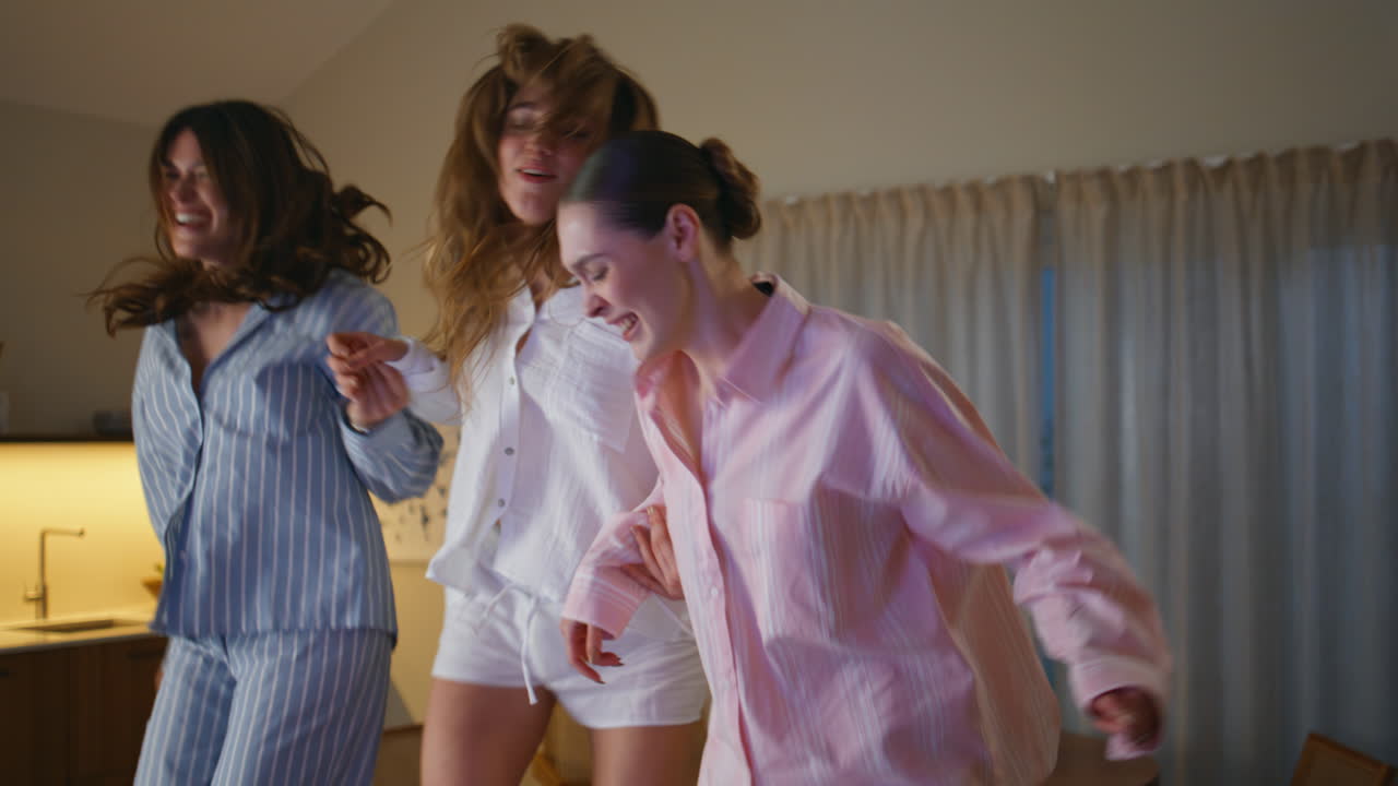 Excited women jumping couch throwing confetti at hen party home closeup