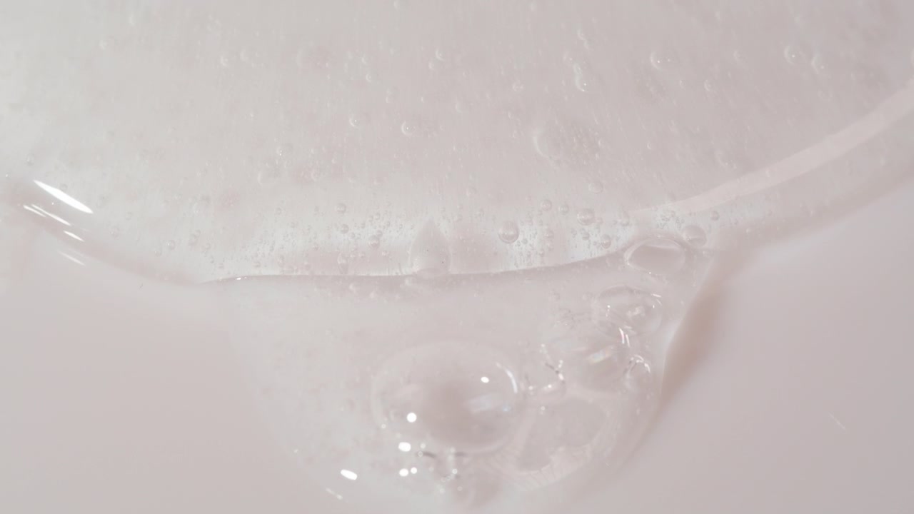 Gel trasparente con bolle che si spande su una superficie bianca