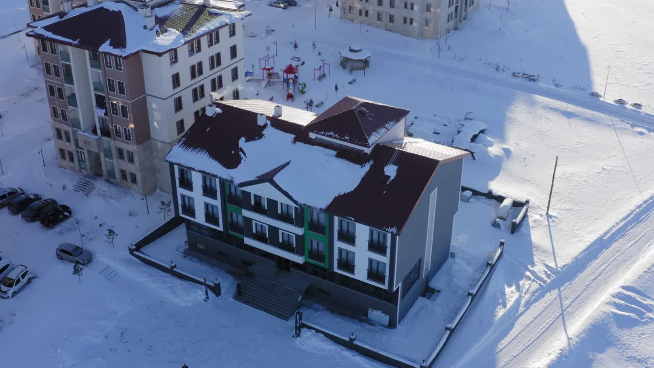 edificios de apartamentos aéreos cubiertos de nieve con vapor de los techos durante el atardecer