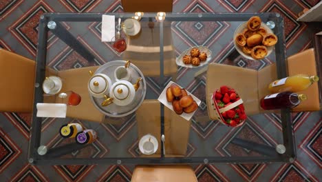 top-down shot showing a selection of pastries and fruit on a table for breakfast