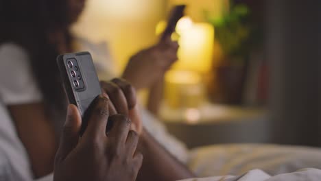 Close-Up-Of-Couple-With-Relationship-Problems-At-Home-At-Night-Both-Looking-At-Mobile-Phones-In-Bedroom-10