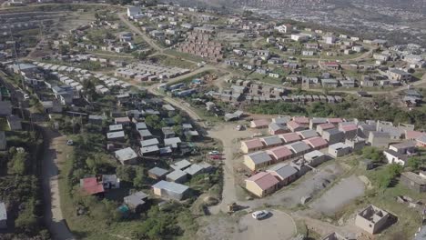 Aerial:-New-home-construction-in-Xolweni-Township-above-Knysna,-Africa