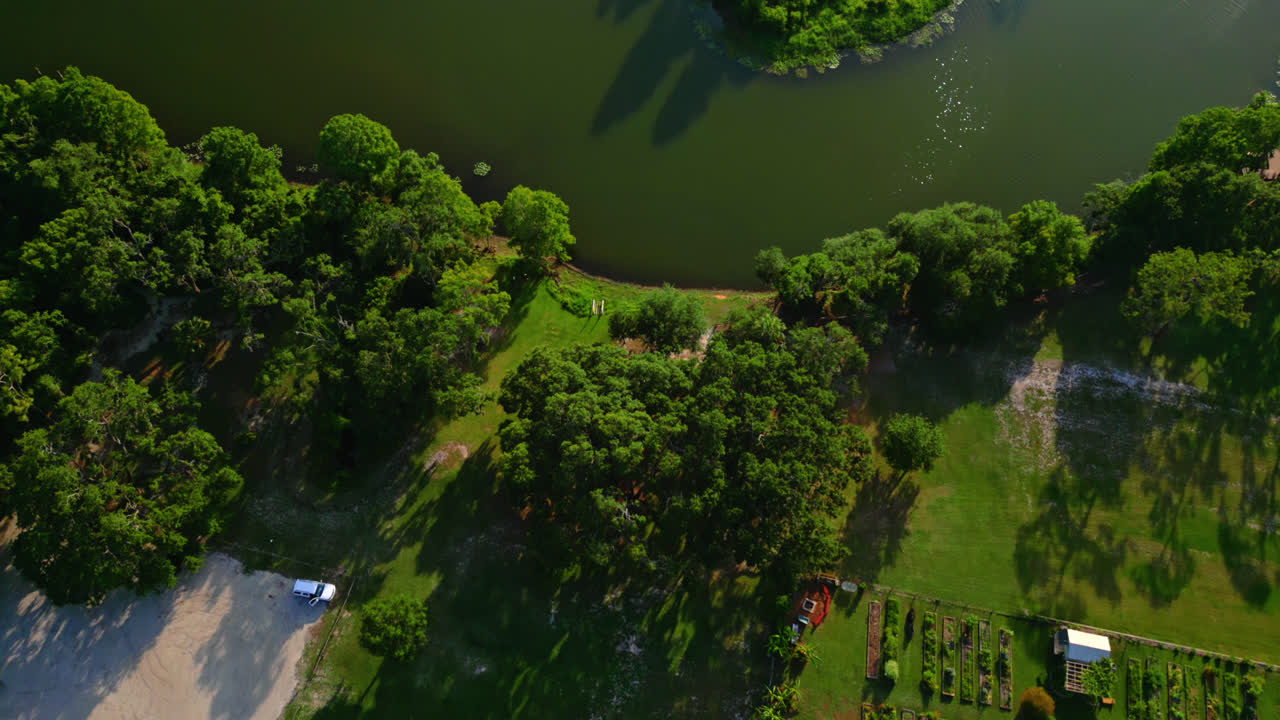 Aerial flyover the green water and tree lined banks of Hillsborough River Park in Tampa, Florida, establishing waters