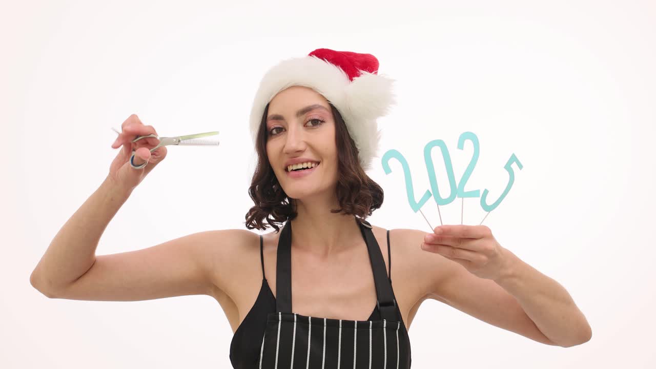 Woman in Santa Hat with 2023 Sign and Scissors for New Year