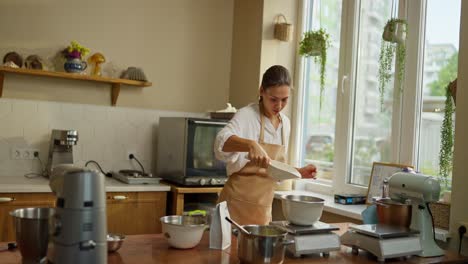 baker in a bakery kitchen preparing a sweet pastry, smiling