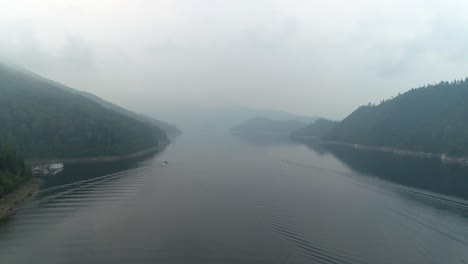 aerial view of a foggy lake surrounded by mountains