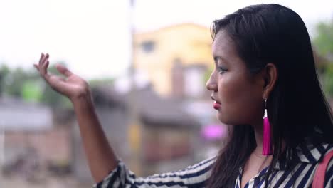 Sad-or-nostalgic-Asian-Girl-catching-raindrops-on-hand-standing-outdoor