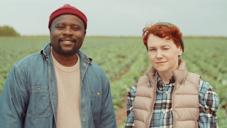 portrait of black man and caucasian woman in farm field