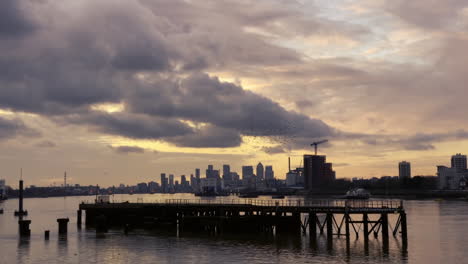 Starling-Murmuration-über-Themse-Mit-Canary-Wharf-Im-Hintergrund