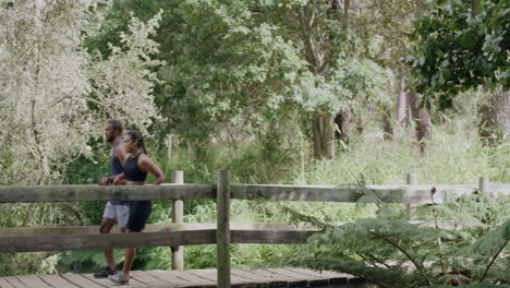 fit couple running and jogging across a bridge