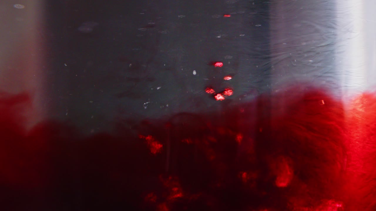 gotas gruesas de sangre cayendo en agua turbia y sangrienta en cámara lenta