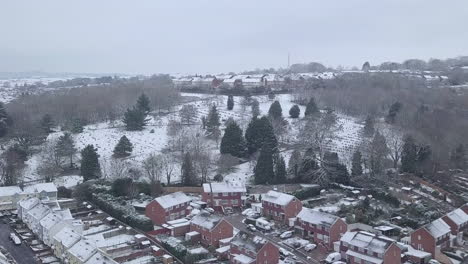 forward tracking drone shot of snowy exeter over a wooded area crop