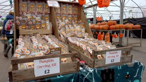 Tilt-shot-of-farmers-store-selling-halloween-pumpkin-carving-sets-for-kids