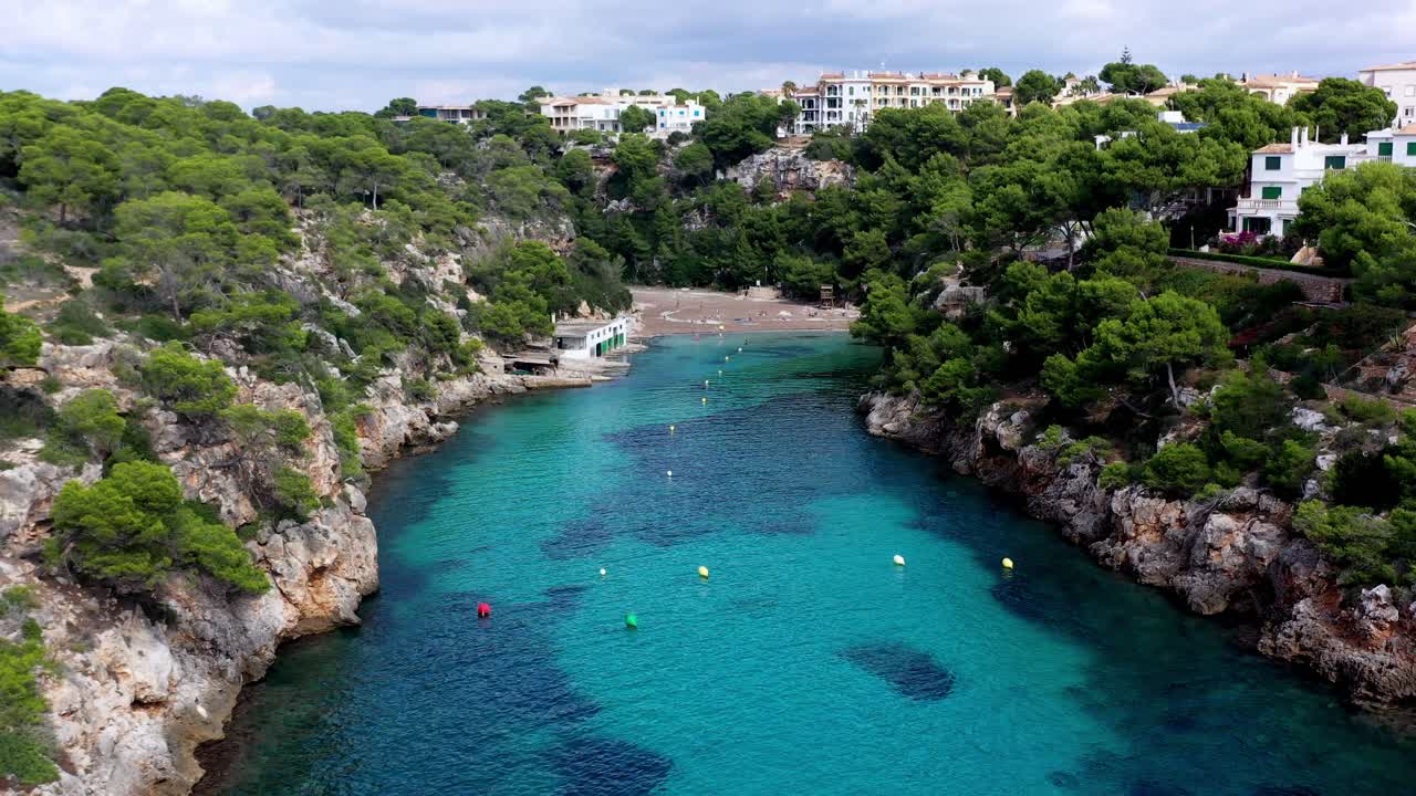 playa de cala pi en mallorca españa entrada turquesa con boyas y bañistas, toma de aproximación de descenso aéreo