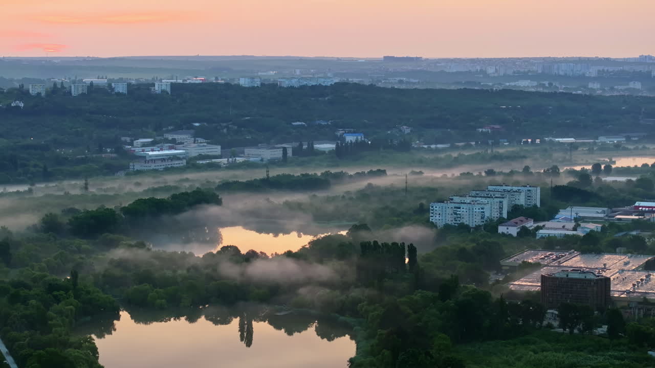 Aerial drone view of a lake surrounded by trees in Chisinau, Moldova at sunrise