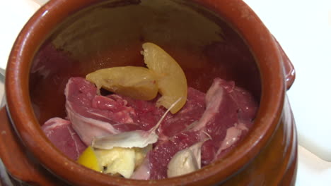 preparing lamb in a traditional pot