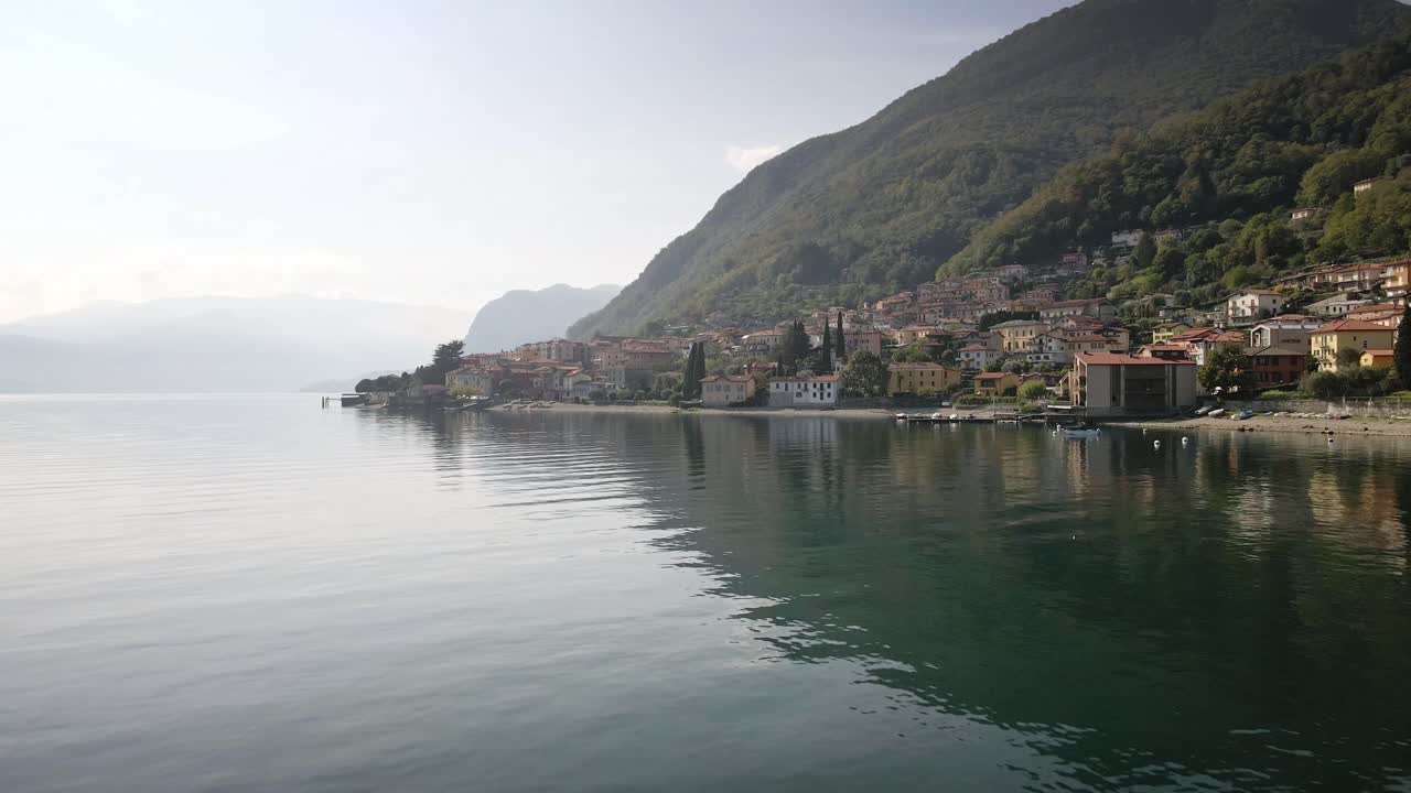 A scenic drone shot over the waters of Lake Como, with the charming town of Acquaseria in the background. The tranquil setting showcases the beauty of Italy’s iconic lake region.