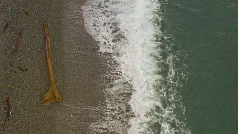 Sea-water-waves-pounding-the-sand-at-the-shore,-Top-View