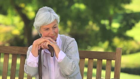 Reife-Frau-Denkt,-Sie-Hält-Ihren-Gehstock