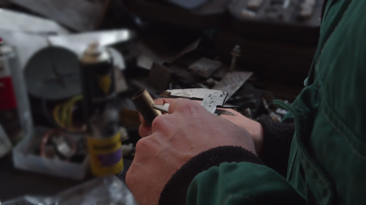 las manos del técnico usan un calibrador para medir el diámetro de los pernos y las tuberías