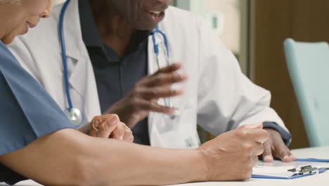 Mid-Section-Two-médico-Professionals-in-Discussion-In-Office