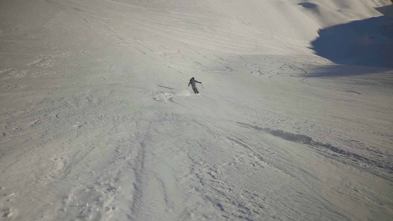 increíble freeride fuera de pista esquiador bajando una carrera de polvo profundo con un épico cielo azul y fondo de montaña telón de fondo, demostrando sentimientos de diversión felices vacaciones de esquí de invierno de aventura