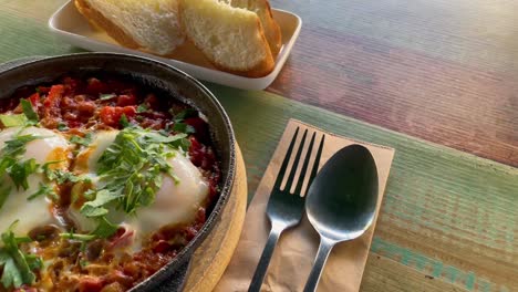 vista de cerca de la tradicional shakshouka, huevos asados en salsa de tomate, aceite de oliva, pimientos, cebolla y ajo, baja cantidad de carbohidratos, comida keto.