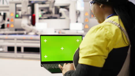 vertical video engineer in photovoltaics factory using chroma key laptop to look at metrics