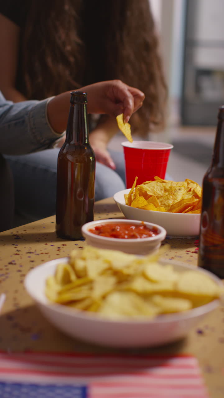 video vertical de amigos bebiendo cerveza y comiendo bocadillos en una fiesta que celebra el día de la independencia de estados unidos el 4 de julio