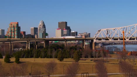 the skyline of louisville kentucky behind bridges over the ohio river