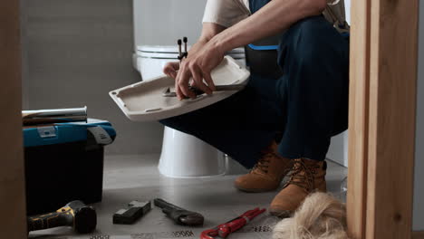 un plombier qui répare les toilettes.