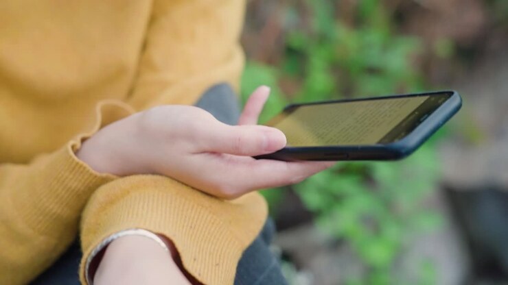 Young asian woman reading ebook with thermos in her hand