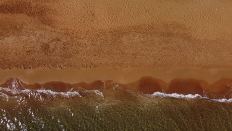 aerial top view of waves on the shore, clay beach, greece