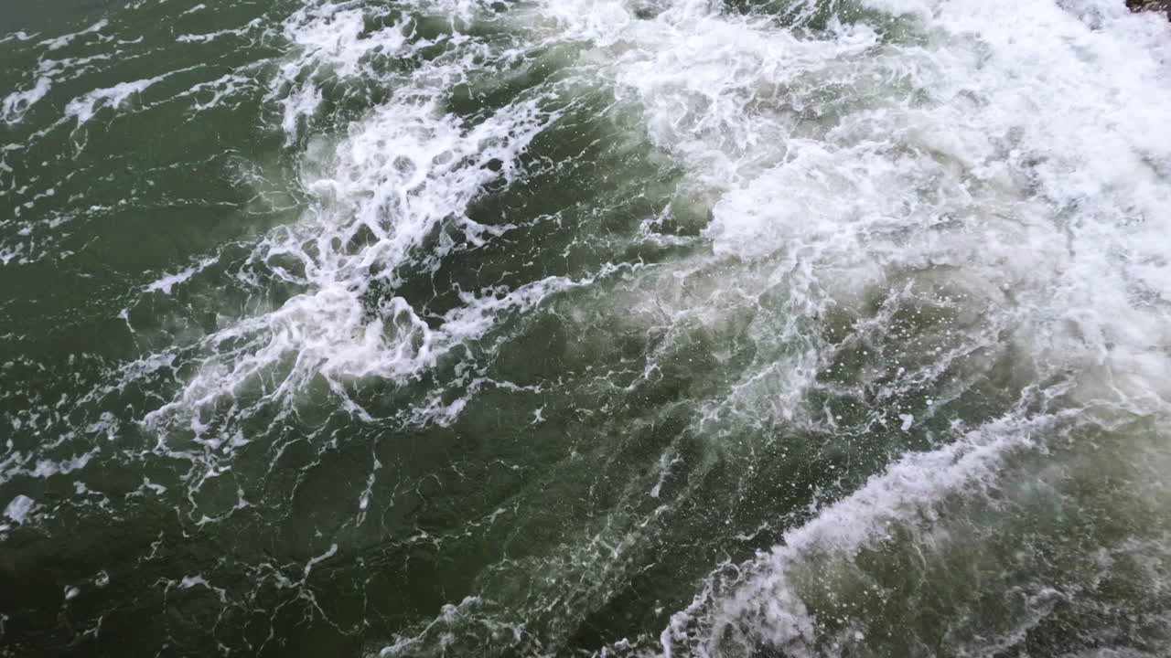 4k Static shot of waves and rocks in the ocean water