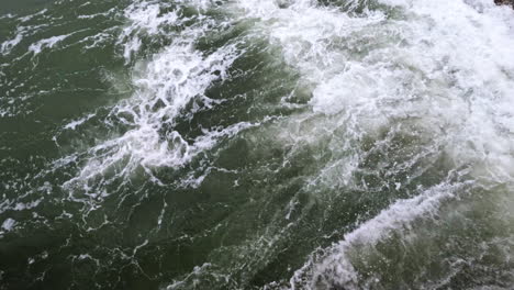 4k static shot of waves and rocks in the ocean water