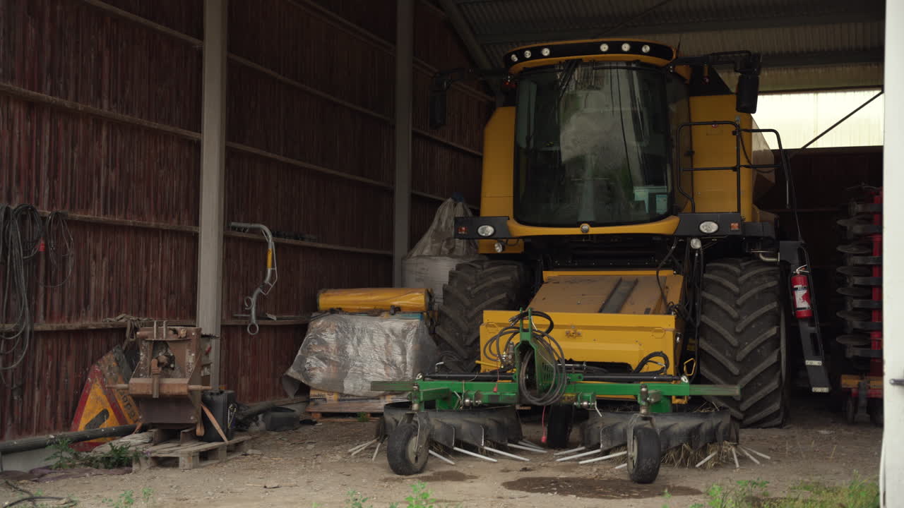 Medium shot of combine harvester parked in a barn